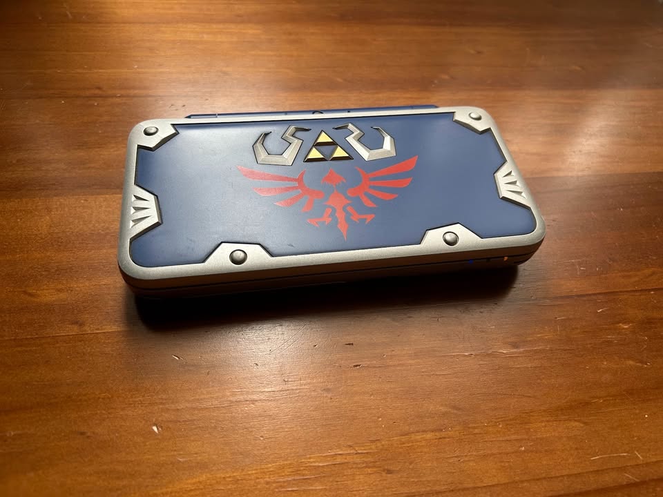 Sienna Nintendo New 2DS XL Hylian Shield Edition + Cargador Original – Edición Especial Zelda