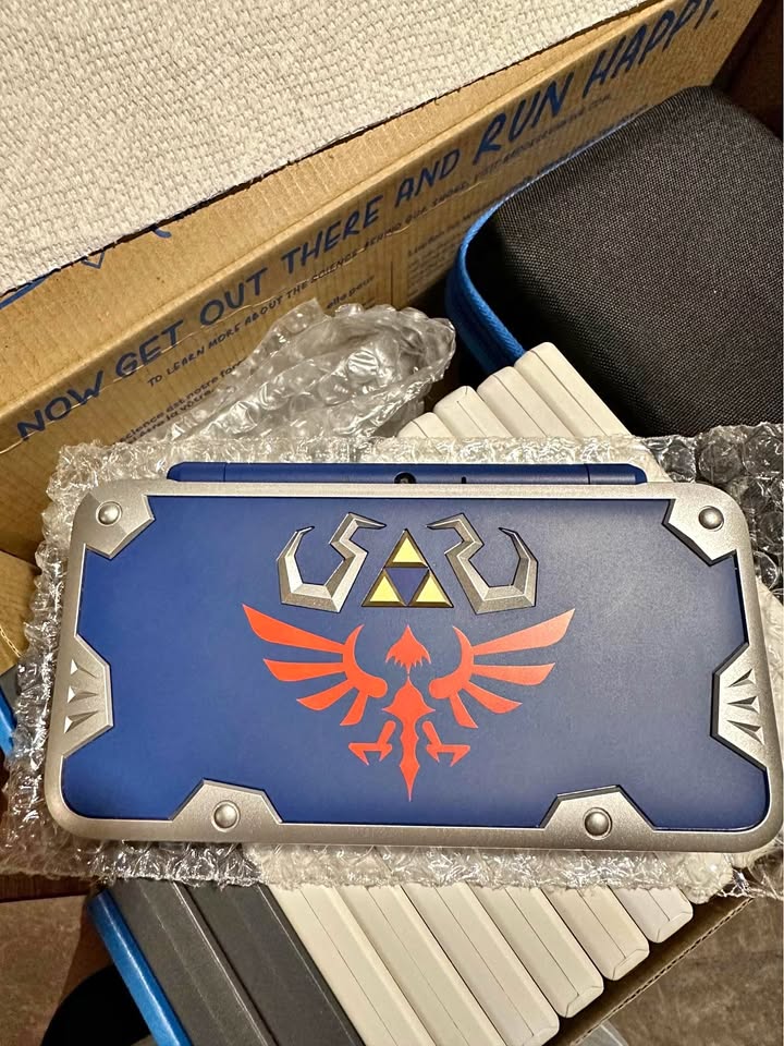 Tan Nintendo New 2DS XL Hylian Shield Edition + Cargador Original – Edición Especial Zelda